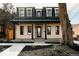 Charming two-story home with a black metal roof, covered porch, and landscaped front yard at 1016 28Th St, Denver, CO 80205