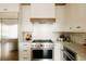 Bright kitchen features white cabinetry, stainless steel appliances, a mosaic backsplash, and wood accents at 1016 28Th St, Denver, CO 80205