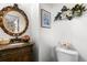 Elegant powder room with a decorative mirror, vanity, and floral accents at 9567 Brentwood Way # A, Broomfield, CO 80021