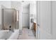 Bright bathroom featuring a tub, shower, and doorway leading to the hallway at 9567 Brentwood Way # A, Broomfield, CO 80021