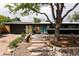 Charming single-story home boasting mature trees, xeriscaping, and a welcoming stone pathway to the front door at 3605 W Berry Ave, Littleton, CO 80123