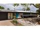 Contemporary single-story home features a blue front door, xeriscaping, and solar panels for energy efficiency at 3605 W Berry Ave, Littleton, CO 80123