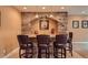 Finished basement with a wet bar, stone accents, and bar stools at 9850 Sunset Hill Circle Cir, Lone Tree, CO 80124