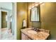 Convenient half bathroom with granite countertop and a framed mirror at 9850 Sunset Hill Circle Cir, Lone Tree, CO 80124