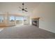 Open living room featuring neutral carpet, a fireplace, vaulted ceiling, and large windows at 3342 Quail Ridge Cir, Parker, CO 80138