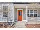 Charming front entrance with a vibrant orange door and covered porch, creating a welcoming curb appeal at 1495 Zamia Ave # 3, Boulder, CO 80304