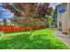 Large backyard with a well-manicured lawn, patio, privacy fence, and established trees at 14878 E Aberdeen Ave, Centennial, CO 80016