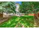 Beautiful backyard with a patio, green lawn, mature trees, and a privacy fence at 14878 E Aberdeen Ave, Centennial, CO 80016