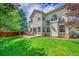 Spacious backyard with a patio, stone accents, large windows, and mature trees at 14878 E Aberdeen Ave, Centennial, CO 80016