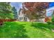 Expansive backyard featuring lush lawn, patio, mature trees, and privacy fence at 14878 E Aberdeen Ave, Centennial, CO 80016
