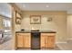 Basement kitchenette with wooden cabinets and a mini fridge, plus bonus storage at 14878 E Aberdeen Ave, Centennial, CO 80016