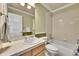 Neutral bathroom features a tub, shower, and single sink vanity with tiled countertop at 14878 E Aberdeen Ave, Centennial, CO 80016