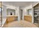 Well-lit bathroom featuring dual vanities, a walk-in closet, and neutral tile flooring at 14878 E Aberdeen Ave, Centennial, CO 80016