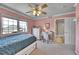 Pink bedroom includes a ceiling fan, desk, large window, and an ensuite bathroom at 14878 E Aberdeen Ave, Centennial, CO 80016