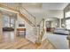 Grand foyer with hardwood floors, a staircase with white railing and views into living and dining areas at 14878 E Aberdeen Ave, Centennial, CO 80016