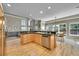 Open kitchen with stainless steel appliances, natural wood floors, and access to dining room at 14878 E Aberdeen Ave, Centennial, CO 80016