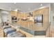 Spacious kitchen featuring light wood cabinetry, stainless steel appliances and a granite countertop island at 14878 E Aberdeen Ave, Centennial, CO 80016