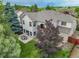 Spacious backyard featuring a stone patio with outdoor seating, mature trees, and lush lawn for entertaining and enjoying at 14878 E Aberdeen Ave, Centennial, CO 80016