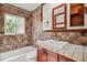 Bathroom featuring a mosaic tile shower, window, and traditional vanity at 4624 S Lincoln St, Englewood, CO 80113