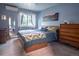 This cozy bedroom has ample light and is complemented by wood furnishings and mountain art at 2557 S Dover St # 85, Lakewood, CO 80227