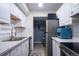 Well-lit kitchen featuring white cabinets, stainless steel appliances, and a view to the laundry area at 2557 S Dover St # 85, Lakewood, CO 80227