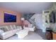 Bright living room with two sofas, a modern coffee table, and a staircase in the background at 2557 S Dover St # 85, Lakewood, CO 80227