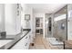 Modern bathroom with gray countertop, stylish cabinets, a glass-enclosed shower, and an organized walk-in closet at 15353 E 98Th Pl, Commerce City, CO 80022