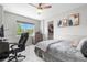 Bright bedroom with a comfortable bed, an oversized desk, and a window that overlooks the mature trees at 15353 E 98Th Pl, Commerce City, CO 80022