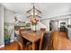 Open dining room with a table set for six, wood floors, and a modern light fixture at 15353 E 98Th Pl, Commerce City, CO 80022