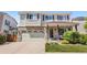 Charming two-story home featuring a brick facade, well-maintained lawn, and attached two-car garage at 15353 E 98Th Pl, Commerce City, CO 80022