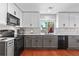 Kitchen with granite counters, stainless appliances, gray lower and white upper cabinets, and subway tile backsplash at 15353 E 98Th Pl, Commerce City, CO 80022
