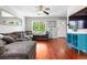 Comfortable living room with hardwood floors, a cozy sectional couch, and ample natural light at 15353 E 98Th Pl, Commerce City, CO 80022