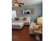 Bright living room with hardwood floors, comfortable white sofa, decorative pillows, and stylish ceiling fan and lamp at 15353 E 98Th Pl, Commerce City, CO 80022
