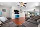 Cozy living room features hardwood floors, large sectional sofa, and stone fireplace at 15353 E 98Th Pl, Commerce City, CO 80022