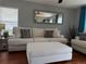 Cozy living room with white sofas, hardwood floors, neutral walls, large mirror and a ceiling fan with integrated lighting at 15353 E 98Th Pl, Commerce City, CO 80022