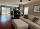 Open living room featuring a fireplace, hardwood floors, white sofas, backyard access and views into the kitchen at 15353 E 98Th Pl, Commerce City, CO 80022