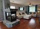 Living room featuring a modern fireplace with stone accents, white sofas, and a decorative ceiling fan and lighting at 15353 E 98Th Pl, Commerce City, CO 80022