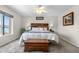 Spacious main bedroom with a wood accent wall, large window, and a vintage trunk at the end of the bed at 15353 E 98Th Pl, Commerce City, CO 80022