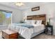 Bright and spacious primary bedroom featuring a cozy wood headboard and soft, natural lighting at 15353 E 98Th Pl, Commerce City, CO 80022