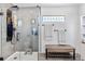 Modern shower with sleek black hardware, glass doors, a built-in bench, and a window for natural light at 15353 E 98Th Pl, Commerce City, CO 80022