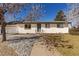 Charming ranch-style home with a white brick exterior, a well-manicured lawn, and a walkway to the front door at 6699 S Pennsylvania St, Centennial, CO 80121