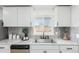 The bright kitchen features stylish gray tile backsplash and white stone countertops at 6699 S Pennsylvania St, Centennial, CO 80121