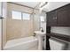 Bathroom featuring a bathtub, pedestal sink, and tiled walls at 1420 S Leyden St, Denver, CO 80224