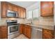 Kitchen showcasing stainless steel appliances, tile backsplash, and wooden cabinets at 1420 S Leyden St, Denver, CO 80224