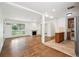 Open-concept living room with a fireplace, hardwood floors, and seamless flow to the kitchen at 1420 S Leyden St, Denver, CO 80224