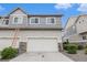 Two-story townhome featuring a two-car garage and stone veneer accents for a stylish and modern look at 20000 E 40Th Ave # 4, Denver, CO 80249