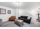 Finished basement living area with a black sofa, leather chair, and framed art at 20000 E 40Th Ave # 4, Denver, CO 80249