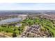 Expansive aerial view showcasing the neighborhood, golf course, lakes, and cityscape in the distance at 4535 W 50Th Ave, Denver, CO 80212