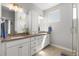 Bright bathroom with double sinks, white cabinetry, quartz countertop and modern fixtures at 4535 W 50Th Ave, Denver, CO 80212