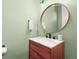 Stylish half bath featuring a wood vanity with marble top, round mirror, and modern fixtures at 4535 W 50Th Ave, Denver, CO 80212